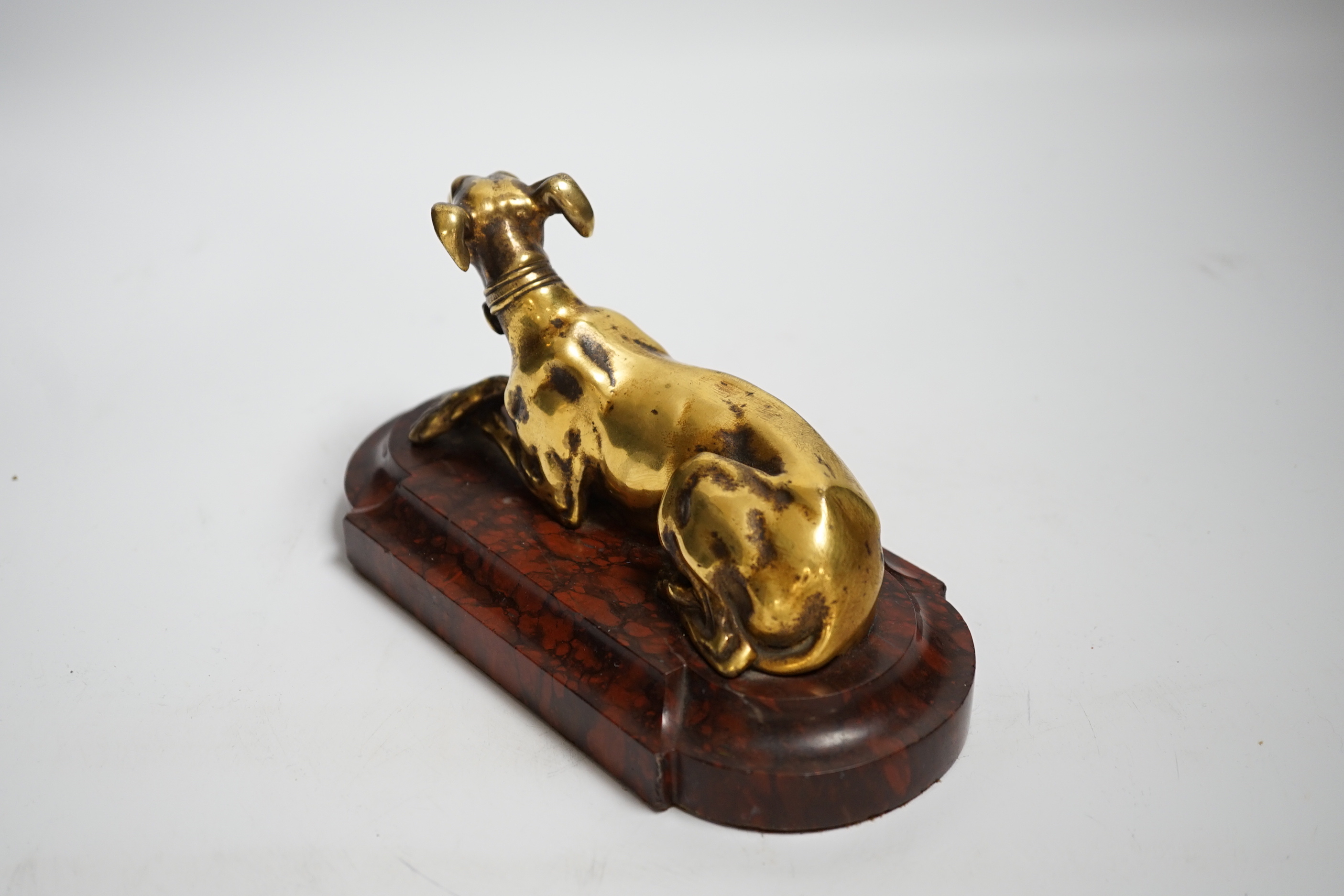 A 19th century French gilt bronze of model of a recumbent greyhound on a rouge marble plinth, 19cm wide